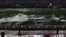 Tampak orang berjalan dipinggir lapangan yang banjir akibat hujan lebat di stadion Monumental, Argentina, Jumat (13/11/2015). Lapangan yang dipakai untuk Pertandingan antara Argentina dan Brasil dihentikan akibat kondisi ini. (REUTERS/Marcos Brindicci)
