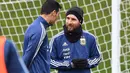 Lionel Messi (kanan) berdiskusi dengan rekannya saat sesi latihan di City Football Academy, Manchester, (20/3/2018). Argentina akan melawan Italia pada laga persahabatan di Etihad Stadiu. (AFP/Anthony Devlin)