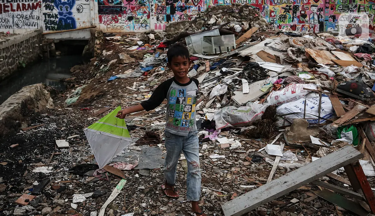Seorang anak bermain di antara reruntuhan rumah di kawasan permukiman Jalan Pancoran Buntu II, Pancoran, Jakarta, Selasa (30/3/2021). Anak-anak yang tidak tahu permasalahan atas sengketa tanah menjadi korban dan terpaksa bermain di sisa reruntuhan tempat tinggal mereka. (Liputan6.com/Johan Tallo)