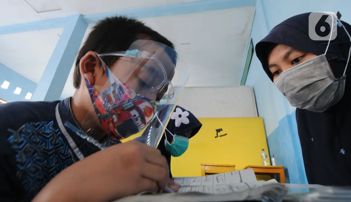 Guru mengajari seorang anak menghapal Al-Quran di Nabinatul Qur'an, Cinere,  Depok, Selasa (20/4/2021). Momentum bulan Ramadhan 14420 H juga dimanfaatkan anak-anak meningkatkan  kemampuan membaca Al-Quran. (merdeka.com/Arie Basuki)