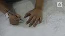Ibu rumah tangga menyelesaikan pembuatan batik kembang mayang di Kampung Batik, Kelurahan Larangan Selatan, Kota Tangerang, Banten, Rabu (26/8/2020). Di tempat yang menjadi destinasi wisata tersebut kita bisa melihat langsung pembuatan dan mengikuti pelatihan membatik. (merdeka.com/Dwi Narwoko)