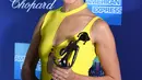 Gal Gadot berpose sambil memegang penghargaan untuk "Wonder Woman" selama Palm Springs International Film Festival 29 tahunan di Palm Springs, California (2/1). Gal Gadot tampil cantik dengan gaun berwarna kuning. (Photo by Jordan Strauss/Invision/AP)