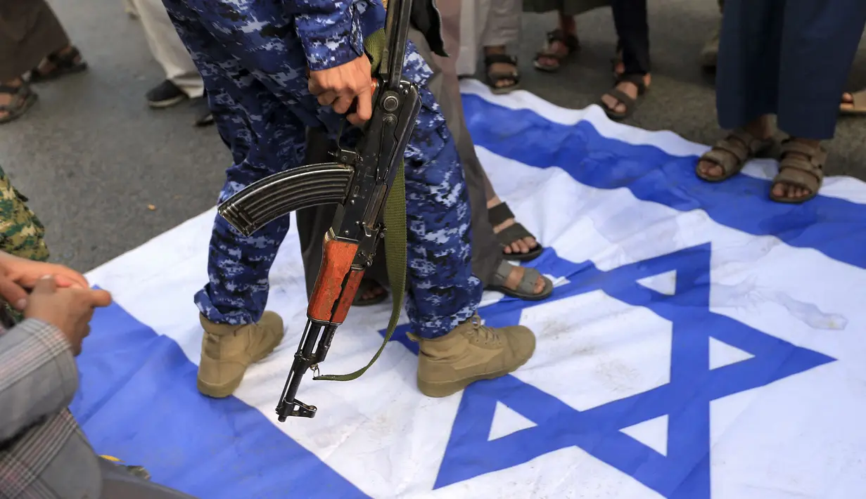 Warga Yaman menginjak bendera Israel selama demonstrasi mengecam pembakaran Al-Quran oleh seorang politisi Swedia di ibu kota Sanaa pada 23 Januari 2023. Politisi sayap kanan Swedia Rasmus Paludan membakar kitab suci umat Islam Al-Quran pada 21 Januari di depan kedutaan Turki di ibukota Swedia. (AFP/Mohammed Huwais)
