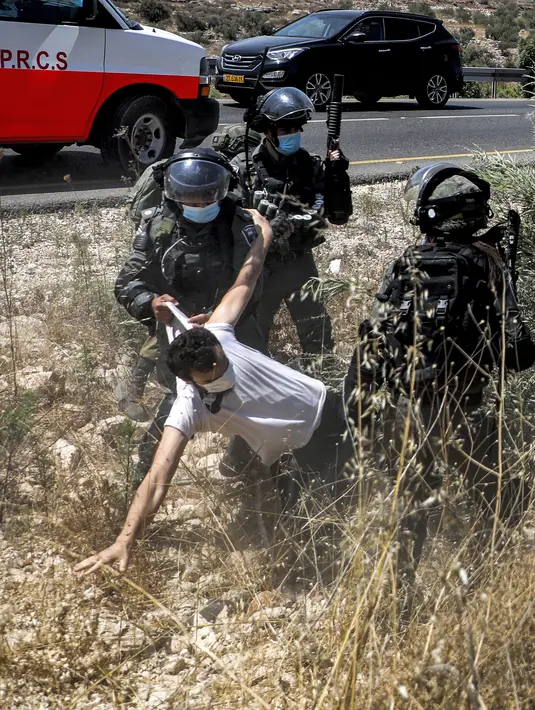 Tentara Israel mengamankan seorang pengunjuk rasa Palestina yang memprotes pembukaan lahan untuk permukiman Israel di dekat Desa Shoufah, wilayah Tepi Barat (20/8/2020). (AFP/JAAFAR ASHTIYEH)