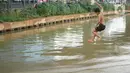 Seorang anak berenang di aliran Sungai Kalimalang, Jakarta, Selasa (18/8/2020). Keterbatasan ekonomi menyebabkan anak-anak tersebut memanfaatkan Sungai Kalimalang sebagai tempat berenang, meskipun berbahaya bagi keselamatan dan kesehatan mereka. (Liputan6.com/Immanuel Antonius)
