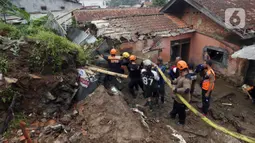 Petugas membersihkan material longsor pada areal pemancingan yang menyebabkan satu orang meninggal dunia di Gang Kepatihan, Kelurahan Kebon Kelapa, Kecamatan Bogor Tengah, Bogor, Jawa Barat, Rabu (12/10/2022). Longsor yang terjadi pada kemarin sore menyebabkan sembilan pemancing tertimbun tanah namun selamat dan seorang anggota kepolisian meninggal. (merdeka.com/Arie Basuki)