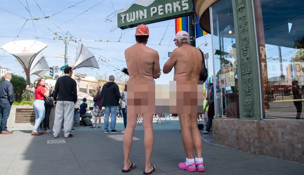 Dua nudis berdiri dekat kafe saat mengikuti acara Nude Love Parade di San Francisco, California, AS, Minggu (17/3). Kaum nudis mempraktikkan, menganjurkan, dan mempertahankan pergaulan telanjang dalam lingkungan pribadi maupun umum. (Josh Edelson/AFP)