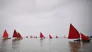 Anggota asosiasi pelayaran budaya berlayar dalam acara Regatta Merah di Venesia, Italia, Minggu (20/6/2021). Red Regatta mengumpulkan lebih dari 50 perahu tradisional Venesia dengan 52 layar warna merah. (MARCO BERTORELLO/AFP)