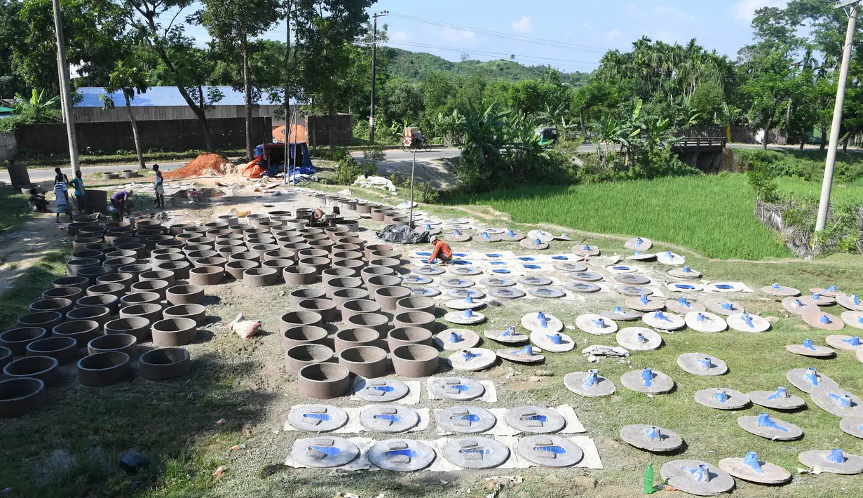 Kesibukan pekerja Bangladesh menyelesaikan pembuatan toilet untuk pengungsi Rohingya di Sonarpara, Cox's Bazar, Rabu (11/10). Gelombang besar masuknya pengungsi Rohingya ke Bangladesh menyebabkan melonjaknya permintaan akan toilet (INDRANIL MUKHERJEE/AFP)
