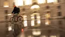 Seorang pengendara sepeda melewati istana Hofburg di alun-alun Michaeler di Wina, Austria, Senin (22/11/2021). Austria kembali menerapkan lockdown penuh untuk mengekang infeksi Covid-19 menyebar ke seluruh Eropa. (JOE KLAMAR / AFP)