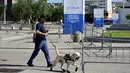 Seorang petugas polisi berjalan dengan anjing pelacak di pintu masuk Pusat Media Konferensi Tingkat Tinggi (KTT) G7 di Bari, Apulia, Italia pada tanggal 12 Juni 2024. (Tiziana FABI/AFP)