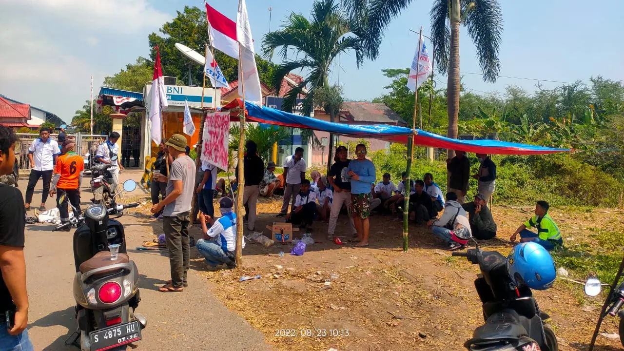 Buruh menggelar tenda keprihatinan di depan pintu masuk PT IKSG Tuban. (Adirin/Liputan6.com)