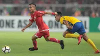 Pemain Persija Jakarta, Riko Simanjuntak (kiri) melewati adangan pemain Tampines Rovers pada laga Piala AFC 2018 di Stadion Utama GBK, Senayan, Jakarta (28/2/2018). Persija menang 4-1. (Bola.com/Nick Hanoatubun)