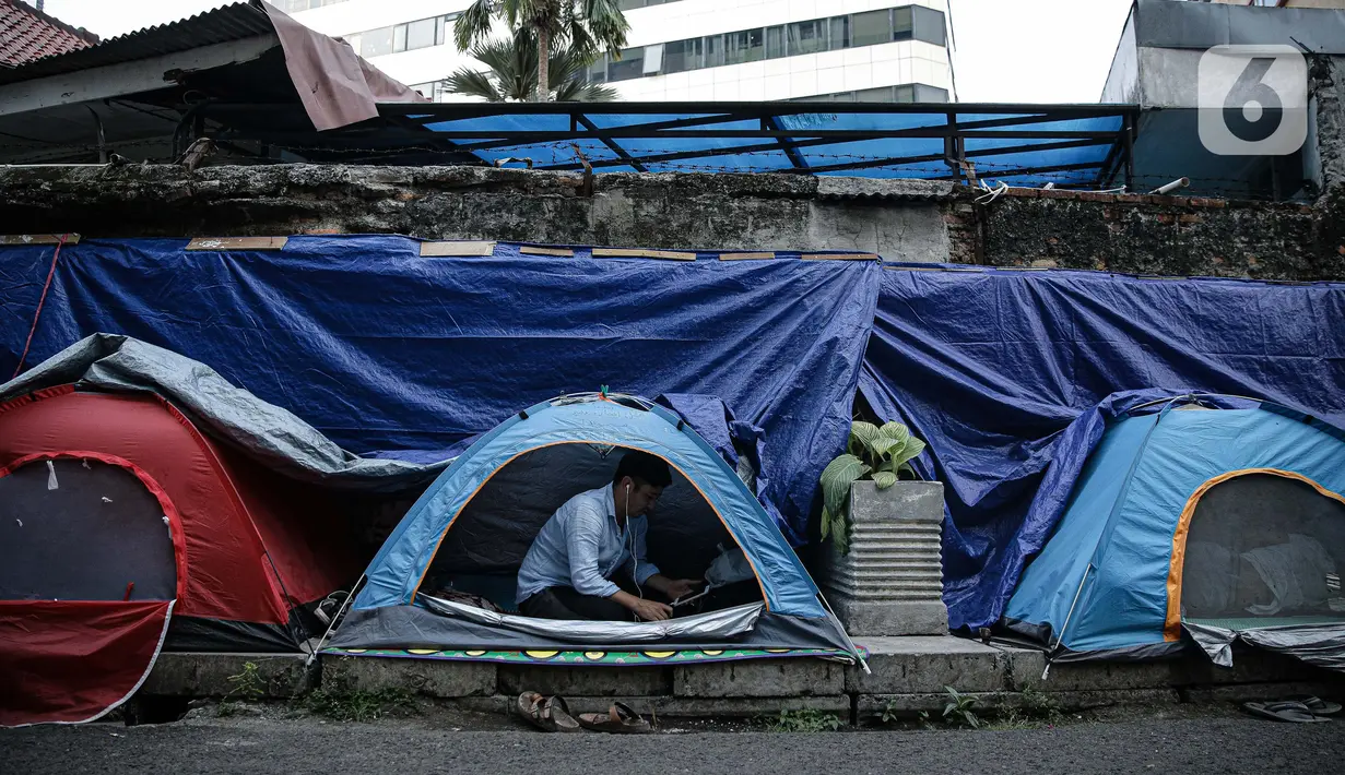Seorang pengungsi Afghanistan berada di dalam tenda di trotoar Kawasan Kebon Sirih, Jakarta, Kamis (26/8/2021). Sebanyak 20 pengungsi asal Afghanistan kembali menempati trotoar dengan harapan bisa diterbangkan ke negara lain dan mendapatkan kehidupan yang lebih layak. (Liputan6.com/Faizal Fanani)