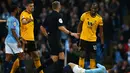 Wasit menghampiri pemain Wolverhampton Wanderers, Willy Boly (kanan) usai melanggar Bernardo Silva dalam pekan ke-22 Premier League di Stadion Etihad, Manchester, Senin (14/1). (AP Photo/Dave Thompson)