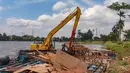 Keberadaan bangunan dan pagar akses menuju setu memicu perhatian publik karena dinilai mengganggu kelestarian kawasan perairan. Tampak dalam foto, petugas Dinas Sumber Daya Air Pemerintah Provinsi Jawa Barat membongkar tiang pancang beton yang dipasang di Setu Tujuh Muara, Sawangan, Depok, Senin (16/01/2026). (Merdeka.com/Arie Basuki)