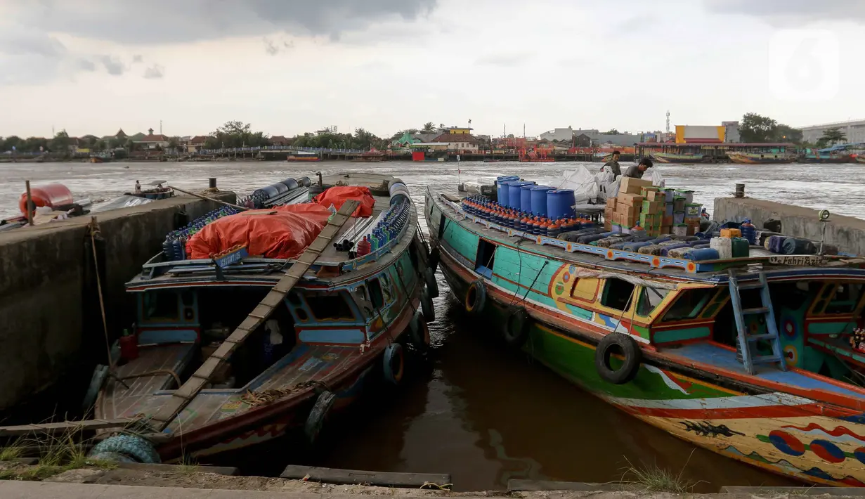 Pekerja mengangkut barang ke kapal di kawasan Dermaga 16 Ilir di tepian Sungai Musi, Palembang, Sumatera Selatan, Rabu (28/5/2025). (Liputan6.com/Herman Zakharia)