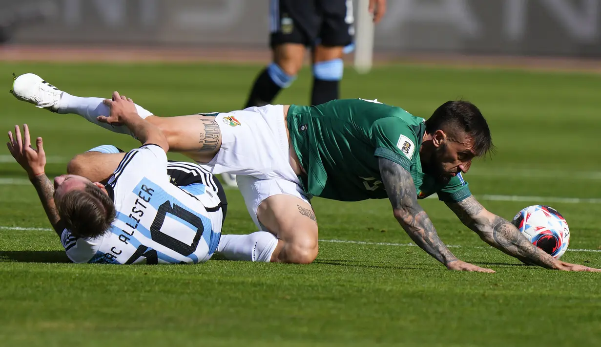 Gelandang Timnas Bolivia, Luciano Ursino (kanan) dan gelandang Timnas Argentina, Alexis MacAllister terjatuh dalam perebutan bola pada laga lanjutan Kualifikasi Piala Dunia 2026 zona Conmebol di La Paz Stadium, Bolivia, Rabu (13/9/2023) dini hari WIB. (AP Photo/Juan Karita)