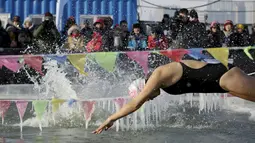 Peserta saat akan melompat ke kolam renang yang terbuat dari sungai Songhua yang membeku pada Kompetisi Renang Es Harbin di Provinsi Heilongjiang, Senin (5/1/2016). (REUTERS/Aly Song)