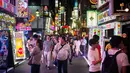 Orang-orang berjalan di distrik Shinjuku, Tokyo pada 22 September 2018. Shinjuku merupakan pusat perniagaan dan pemerintahan metropolitan sekaligus lokasi stasiun terbesar dan tersibuk di dunia. (AFP PHOTO / Martin BUREAU)