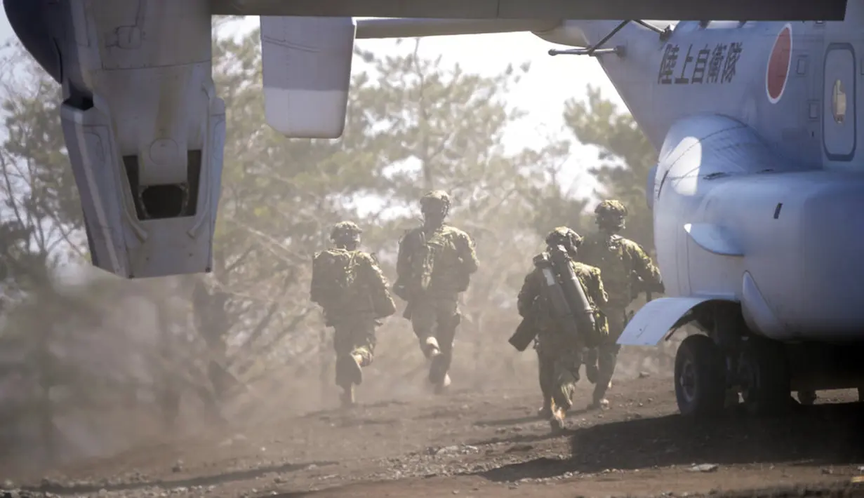 Anggota Pasukan Bela Diri Darat Jepang (JGSDF) bergegas keluar dari osprey V-22 saat mereka mengambil bagian dalam latihan operasi gabungan helikopter militer antara Pasukan Bela Diri Darat Jepang (JGSDF) dan Marinir AS di Higashi Fuji, Gotemba, Jepang, Selasa (15/3/2022). (AP Photo/Eugene Hoshiko)