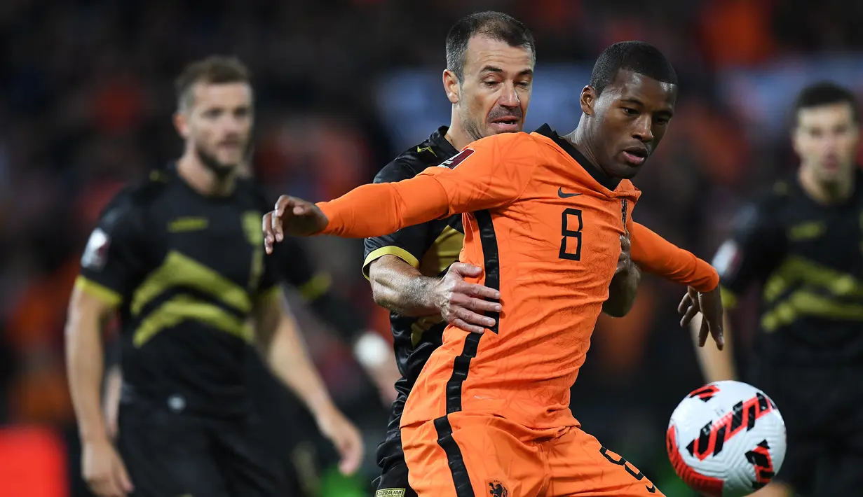 Bek Gibraltar Roy Chipolina (kiri) berebut bola dengan gelandang Belanda Georginio Wijnaldum pada laga Kualifikasi Piala Dunia 2022 zona Eropa Grup G di De Kuip, Rotterdam, Selasa (12/10/2021) dini hari WIB. Menjamu Gibraltar, Belanda menang 6 gol tanpa balas. (JOHN THYS/AFP)