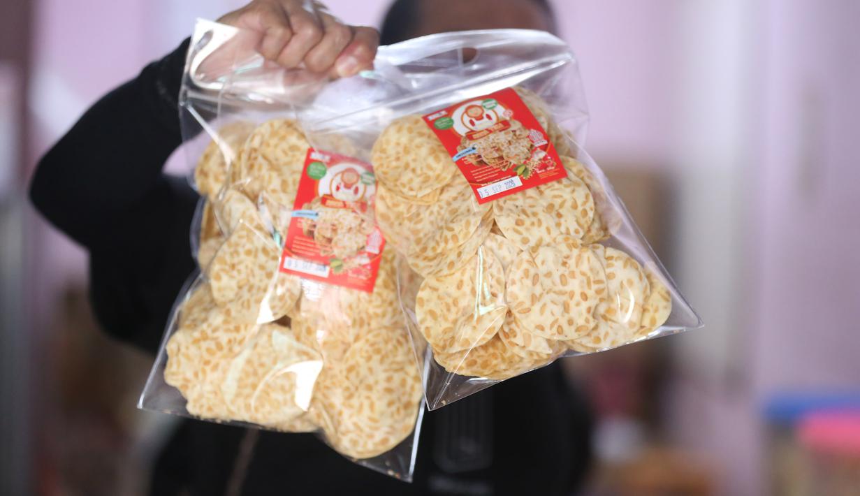 Pekerja menunjukkan salah satu hasil produksi pembuatan keripik tempe di rumah usaha Keripik Tempe Mama Tina, Kebayoran Baru, Jakarta Selatan, Kamis (7/5/2026). Keripik Tempe Mama Tina merupakan usaha rumahan memproduksi keripik tempe dengan beragam varian rasa seperti original bawang putih, balado, barbeque, hingga sapi panggang. (merdeka.com/Arie Basuki)