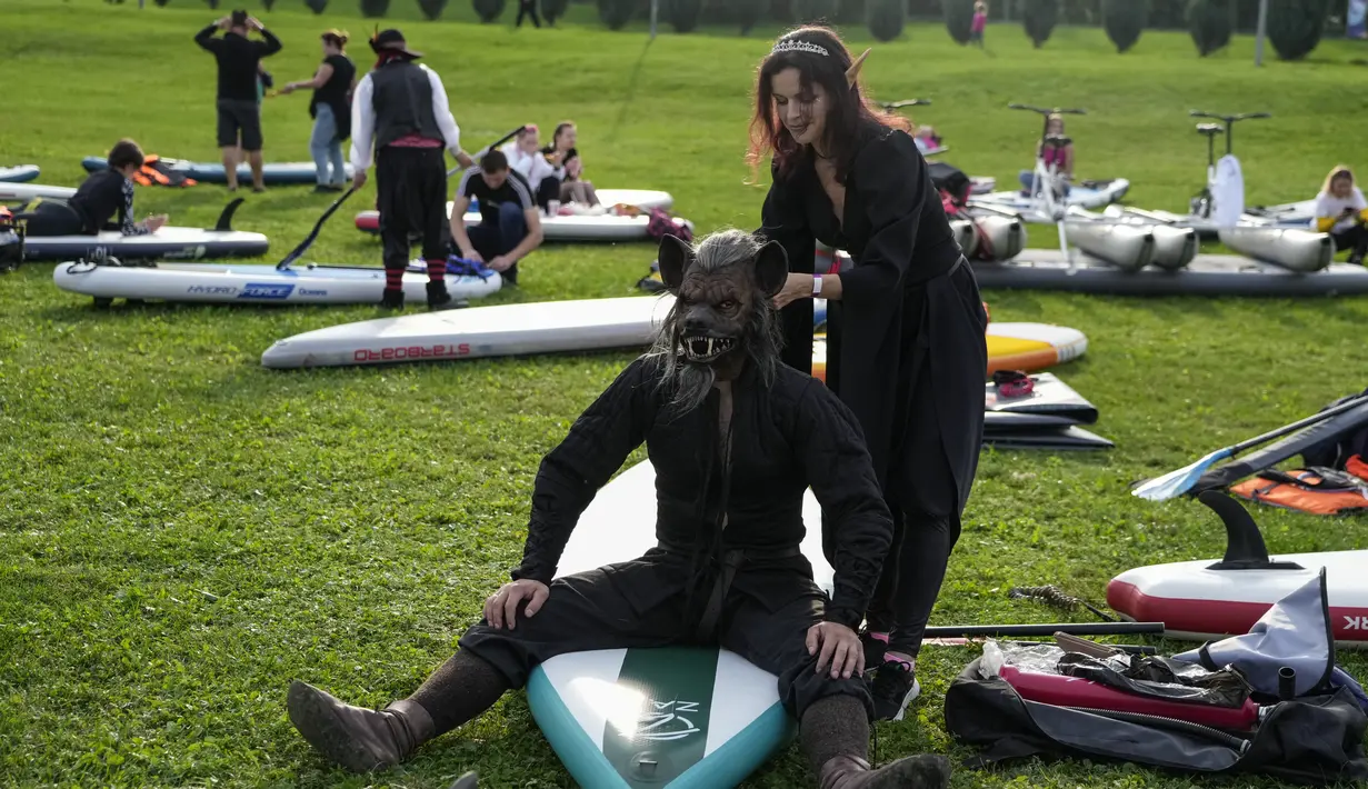 Peserta bersiap untuk memulai festival dayung berdiri (stand up paddle) di kanal dayung Olimpiade Krylatskoye, Moskow, Rusia, Minggu (12/9/2021). Festival dihadiri para peserta dalam balutan kostum warna-warni yang menggambarkan aneka karakter dalam tokoh film. (AP/Pavel Golovkin)