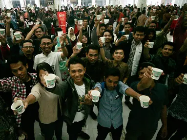 Para pengunjung menikmati kopi pada International Coffee Day di kawasan Babarsari, Yogyakarta, Sabtu (1/10). Panitia membagikan 10.000 kopi kepada pengunjung secara gratis pada peringatan hari kopi sedunia. (Liputan6.com/Boy Harjanto)
