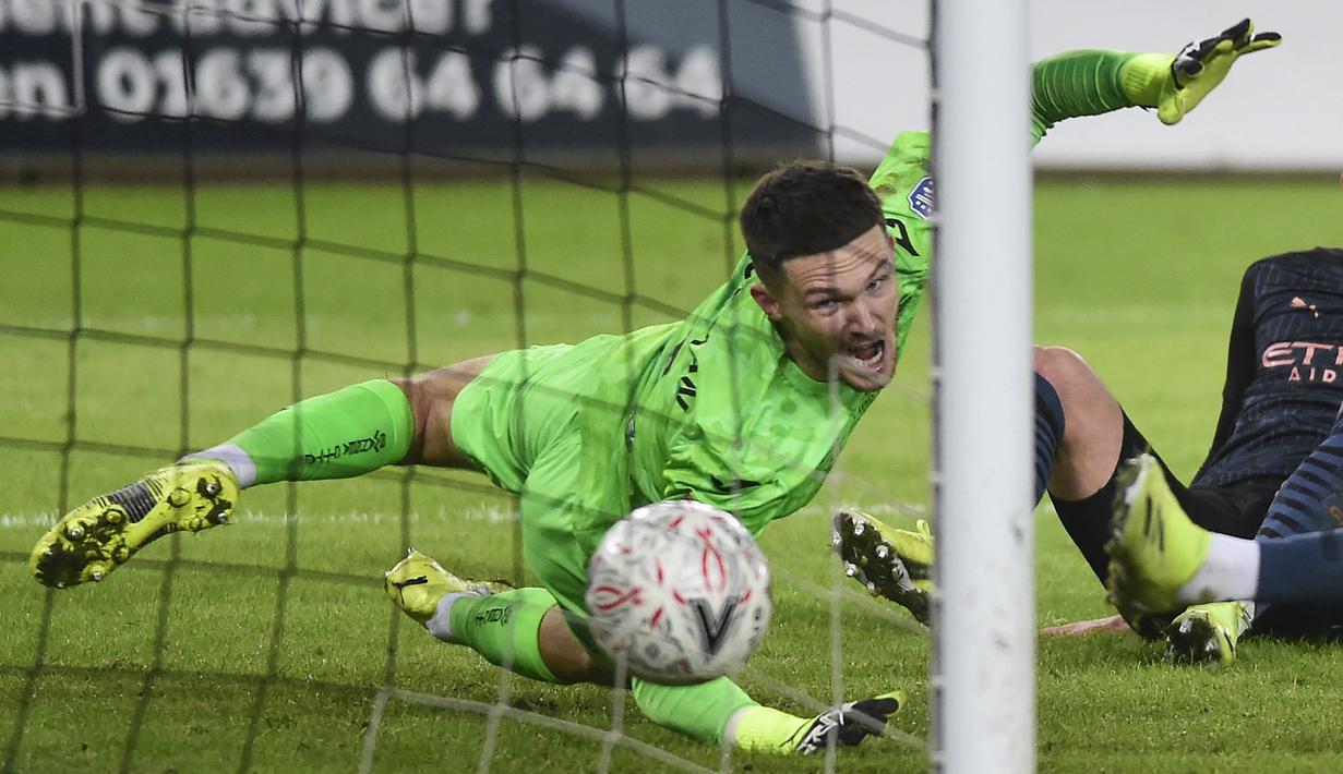 Kiper Swansea City, Freddie Woodman gagal mengantisipasi tendangan bek Manchester City, Kyle Walker yang berbuah gol pertama dalam laga babak kelima Piala FA 2020/21 di Liberty Stadium, Rabu (10/2/2021). Swansea City kalah 1-3 dari Manchester City. (AFP/Rebecca Naden/Pool)