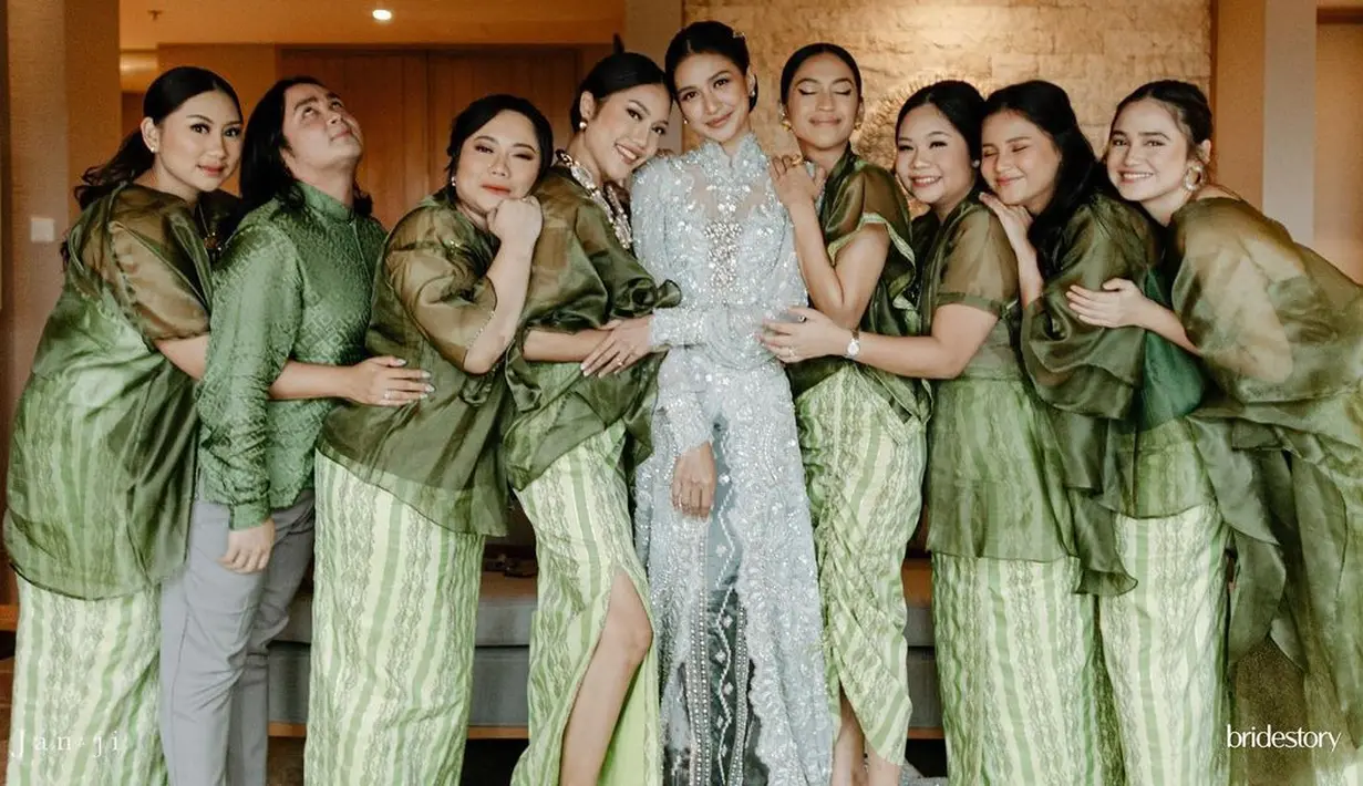 <p>Pada prosesi lainnya saat Mikha menggunakan busana adat Sulawesi, para bridesmaid serasi serba hijau. Pilihan warna hijau botol pada bahan organza yang menjadi atasan terlihat mewah namun simple. [Instagram/miktambayong]</p>