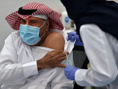 Warga sipil pertama saat menjalani penyuntikan vaksin Covid-19 di pusat vaksinasi yang diawasi Kementerian Kesehatan Arab Saudi di Riyadh, Arab Saudi, Kamis (17/12/2020). Arab Saudi akhirnya memulai vaksinasi Covid-19 setelah menerima dua pengiriman vaksin Pfizer-BioNTech. (AFP/Fayez Nureldine)
