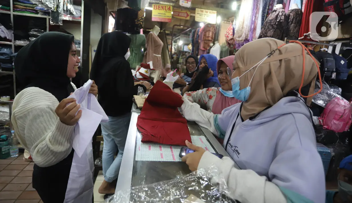Aktivitas jual beli seragam sekolah di Pasar Kebayoran Lama, Jakarta, Jumat (8/7/2022). Menjelang dimulainya tahun ajaran baru, para orang tua disibukkan berbelanja baju seragam dan perlengkapan sekolah untuk anak mereka. (Liputan6.com/Angga Yuniar)