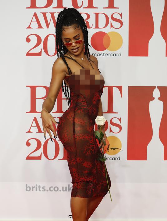 Pose Diana De Brito, yang dikenal sebagai IAMDDB berpose di karpet merah saat tiba menghadiri BRIT Awards 2018 di London, Inggris (21/2). (AFP Photo/Tolga Akmen)