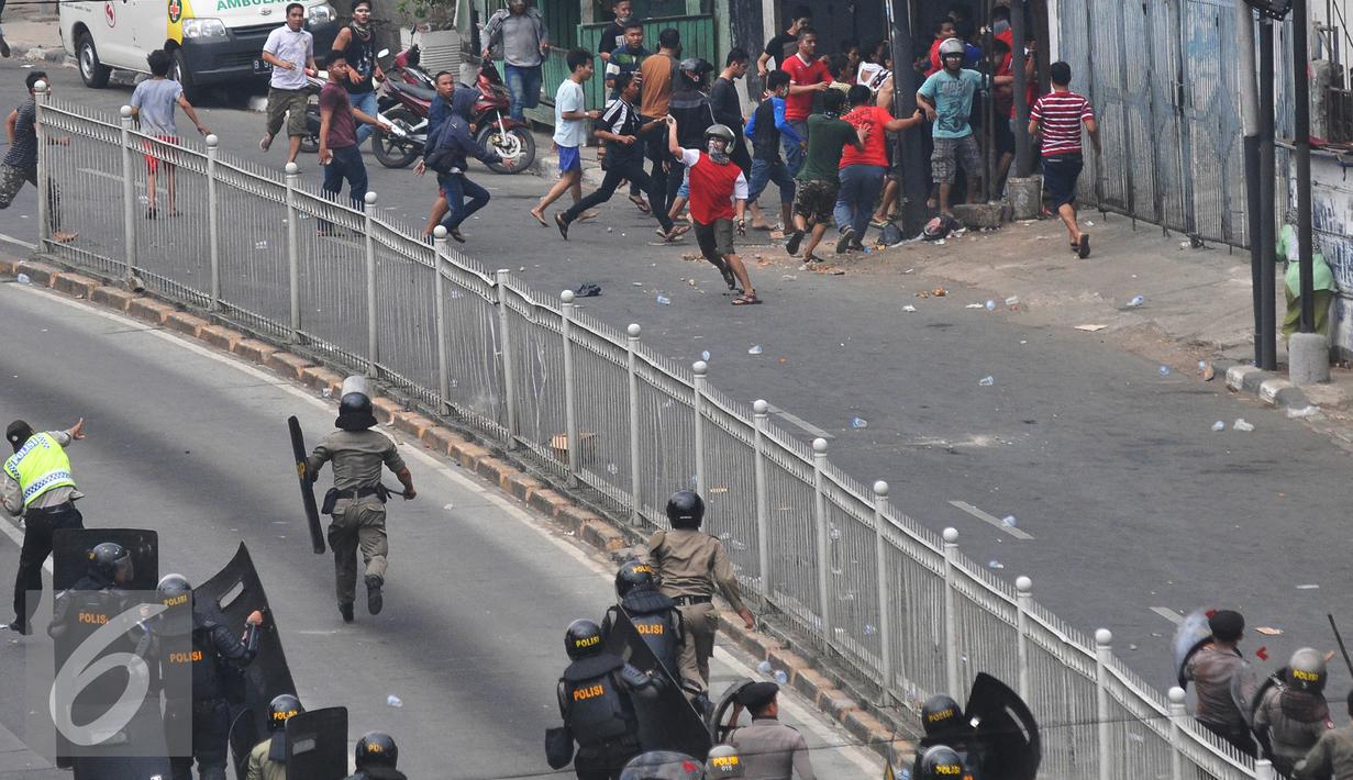 Warga Kampung Pulo saat bentrok dengan petugas gabungan saat penggusuran Kampung Pulo, Jakarta, Kamis (20/8/2015). Penggusuran pemukiman Kampung Pulo dilakukan oleh 2.200 personel gabungan untuk normalisasi Sungai Ciliwung. (Liputan6.com/Herman Zakharia)
