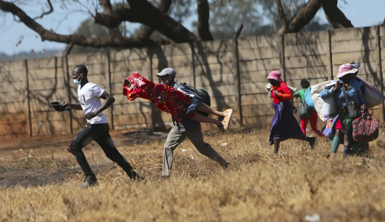 Pedagang Zimbabwe melarikan diri dari polisi setelah mereka diusir dari menjual barang dagangannya dari area yang tidak ditentukan karena pembatasan COVID-19 di Harare, Kamis (29/7/2021). (AP Photo/Tsvangirayi Mukwazhi)