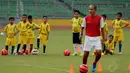 Mantan pemain Timnas Indonesia, Kurniawan Dwi Yulianto memberikan contoh teknik memainkan si kulit bundar kepada anak-anak di Stadion GBK Jakarta, (6/6/2014). (Liputan6.com/Helmi Fithriansyah)