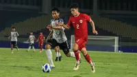 Pemain Timnas Indonesia U-16, Matthew Baker (kanan) menguasai bola dibayangi seorang pemain SKO Ragunan pada laga uji coba di Stadion Manahan, Solo, Rabu (12/6/2024) menjelang keikutsertaan Timnas Indonesia U-16 pada ajang Piala AFF U-16 2024. (Bola.com/Radifa Arsa)