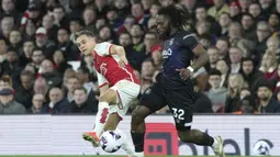 Gelandang Arsenal, Leandro Trossard (kiri) berebut bola dengan gelandang Luton Town, Fred Onyedinma pada laga pekan ke-31 Premier League 2023/2024 di Emirates Stadium, London, Rabu (3/4/2024) malam. (AP Photo/Frank Augstein)