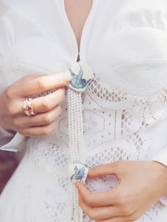 Aksen kancing bergambar burung dan rantai mutiara bikin penampilan Raline Shah terlihat menawan. [@ralineshah]