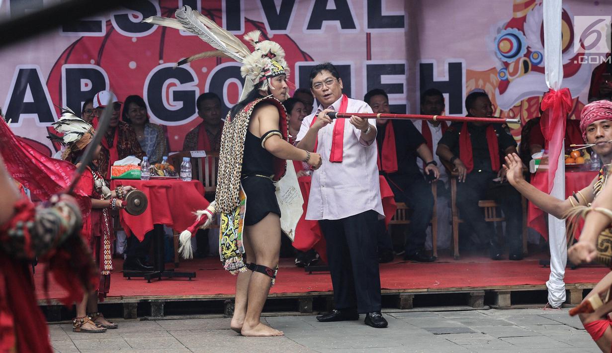 Politikus PDIP Utut Adianto memanah dengan mulut pada acara Festival Cap Go Meh 2570 di Seasons City, Jakarta,  Minggu (24/3). Sekitar 100 tatung pria dan wanita hadir menampilkan atraksi ekstrem menggunakan benda tajam. (Liputan6.com/Fery Pradolo)