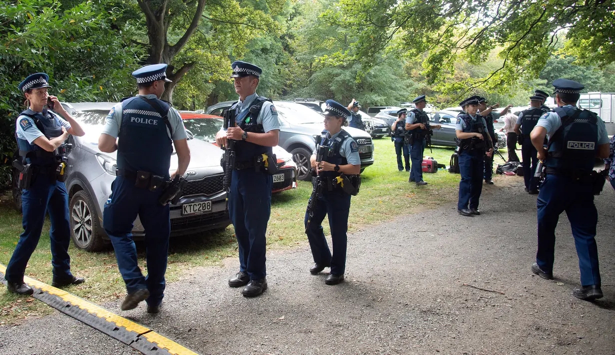 Aparat kepolisian melakukan penjagaan saat pelaksanaan salat Jumat di Hagley Park luar masjid Al-Noor, di Christchurch, Selandia Baru, Jumat (22/3). Ibadah itu digelar sepekan selepas penembakan brutal di kota Christchurch. (Marty MELVILLE / AFP)