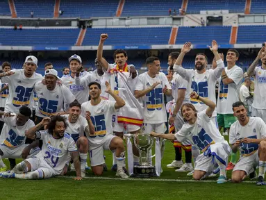 Para pemain Real Madrid berpose dengan trofi gelar La Liga Spanyol usai pertandingan melawan Espanyol di stadion Santiago Bernabeu di Madrid, Sabtu (30/4/2022). Real Madrid menang atas Espanyol 4-0. (AP Photo/Bernat Armangue)