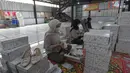 Pekerja melakukan pengepakan produk tas dan sepatu sandal yang akan dikirim ke pelanggan melalui marketplace di bengkel kerja Patris di kawasan Katulampa, Bogor, Jawa Barat, Senin (14/4/2025). (merdeka.com/Arie Basuki)