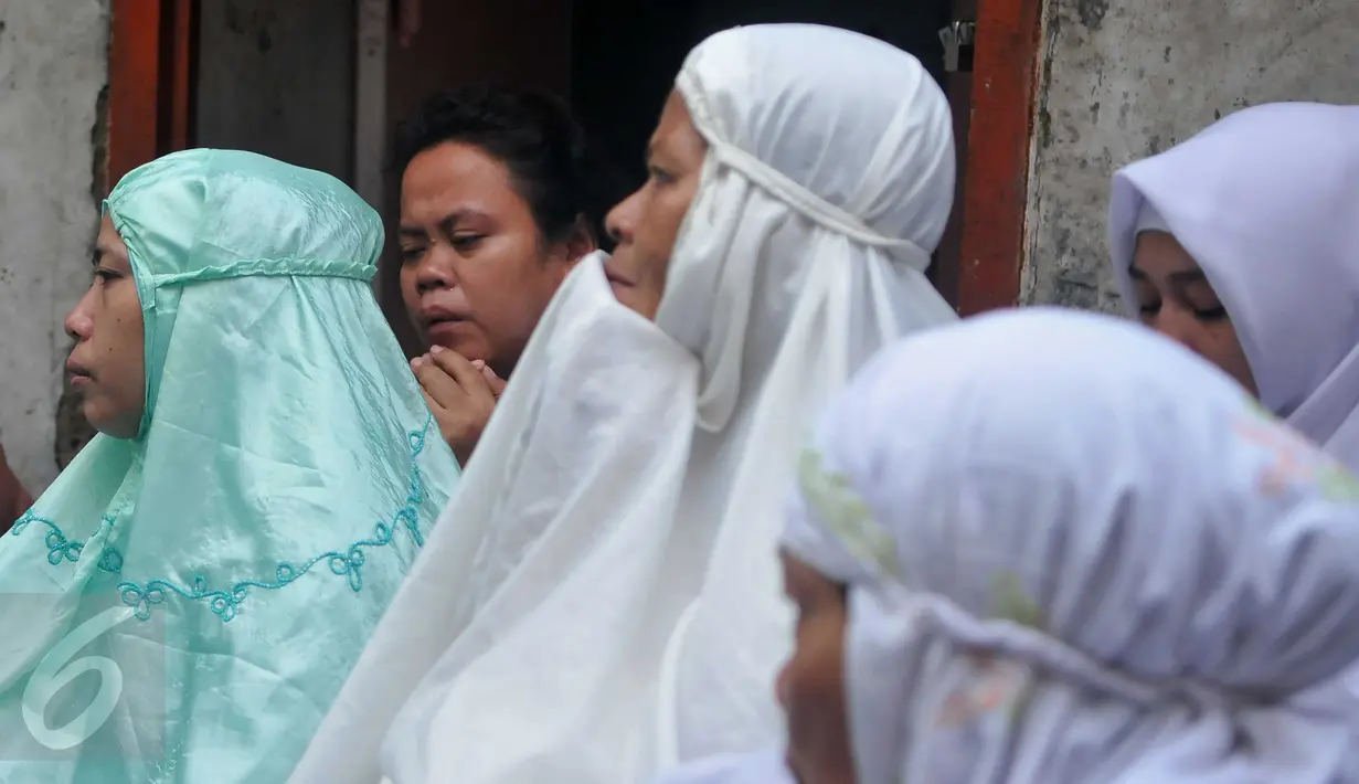 Ekspresi warga saat mengikuti doa bersama jelang penertiban permukiman Kampung Akuarium, Penjaringan, Jakarta, Senin (11/4). Mereka berdoa dengan khusuk di antara gang sempit, dengan menggelar terpal. (Liputan6.com/Gempur M Surya)