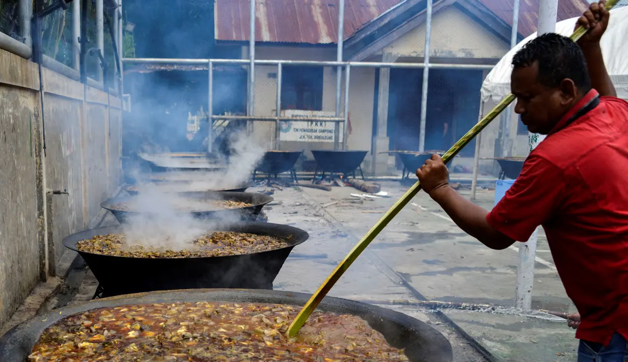 Seorang pria memasak kari tradisional untuk disajikan dalam makanan komunal selama bulan suci Ramadhan di Banda Aceh (25/4/2021). Biasanya, kari tradisional ini juga akan dibagi-bagikan kepada fakir, miskin dan anak yatim. (AFP/Chaideer Mahyuddin)