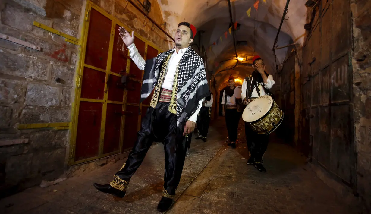Sejumlah pemuda Palestina memainkan musik tradisional saat membangunkan sahur di permukiman Hebron, Tepi Barat, 23 Juni 2015. Tradisi tersebut dilakukan secara turun-temurun untuk mempererat silaturahmi. (REUTERS/Mussa Qawasma)