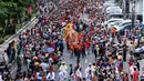 Atraksi liong menembus kerumunan warga di Jalan Gajah Mada, Jakarta, Minggu (4/3). Beragam atraksi budaya yang ada di Indonesia ditampilkan dalam karnaval perayaan Cap Go Meh 2018 di kawasan Glodok Jakarta. (Liputan6.com/Helmi Fithriansyah)