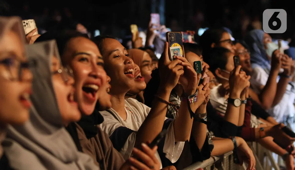 Penonton bernanyi saat menyaksikan konser yang bertajuk 'Tunggu Aku di Jakarta' di kawasan JIExpo Kemayoran, Jakarta, Sabtu, (28/1/2023). Dalam konser yang bertajuk 'Tunggu Aku di Jakarta', Sheila on 7 membawakan lagu-lagu andalannya seperti Pejantan Tangguh, Pria Kesepian, Sephia dan lain-lain. (Liputan6.com/Herman Zakharia)