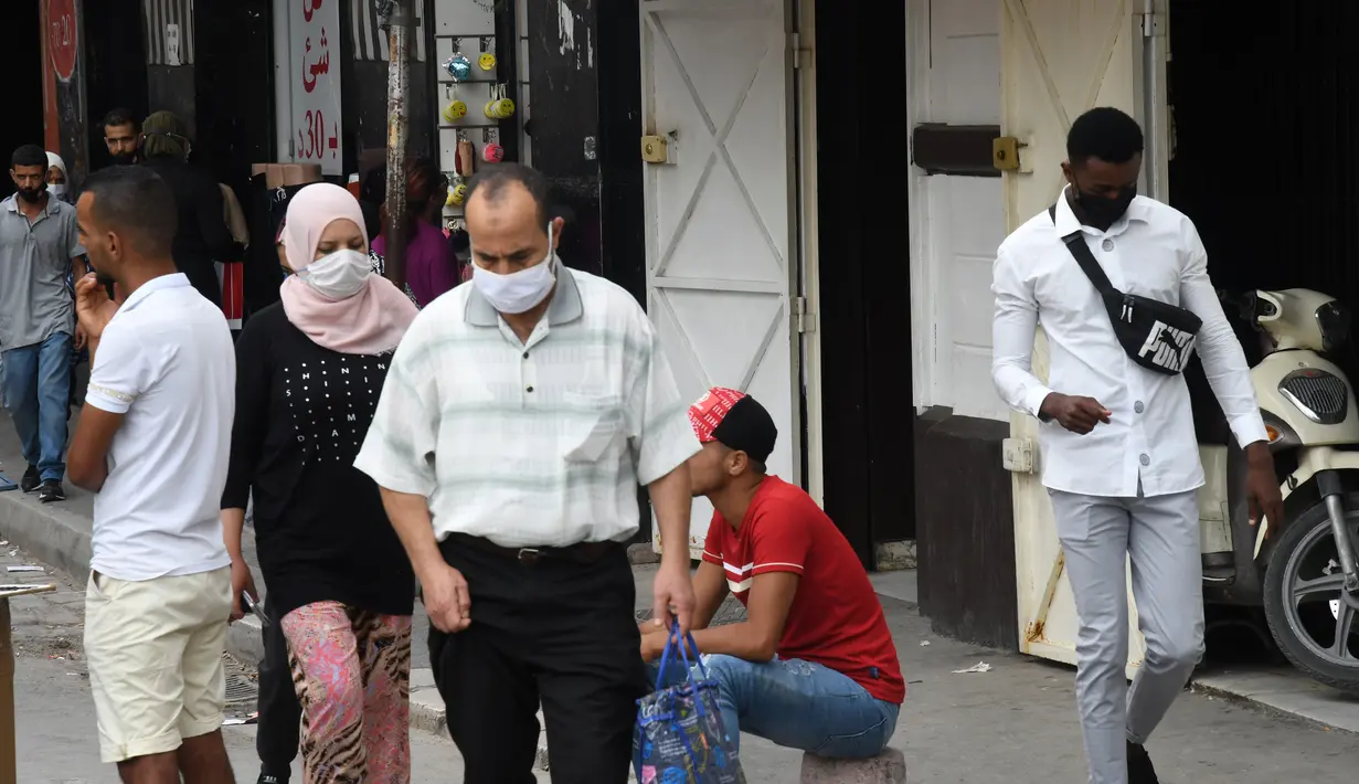 Orang-orang yang mengenakan masker berjalan di sebuah jalan di Tunis, Tunisia, pada 5 Oktober 2020. Perdana Menteri Tunisia Hichem Mechichi pada 3 Oktober mengumumkan serangkaian langkah untuk membatasi penyebaran cepat COVID-19 di negara tersebut. (Xinhua/Adel Ezzine)